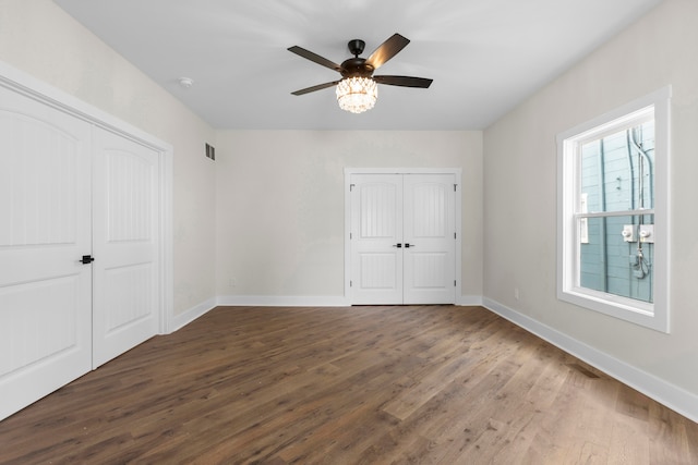 unfurnished bedroom featuring ceiling fan and dark hardwood / wood-style floors