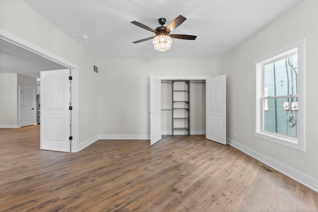 unfurnished bedroom with ceiling fan, hardwood / wood-style flooring, and a closet