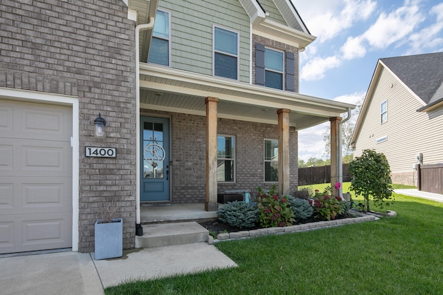 doorway to property featuring a garage, a porch, and a lawn