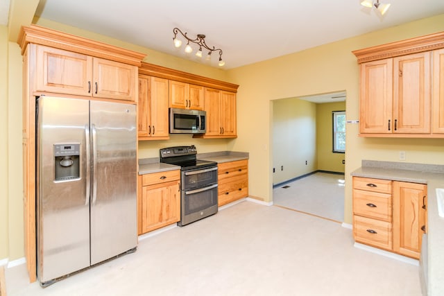 kitchen featuring stainless steel appliances and light brown cabinets