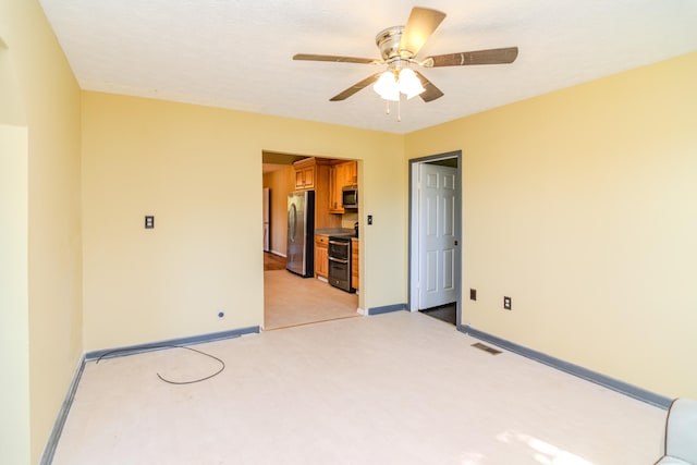 carpeted empty room featuring ceiling fan