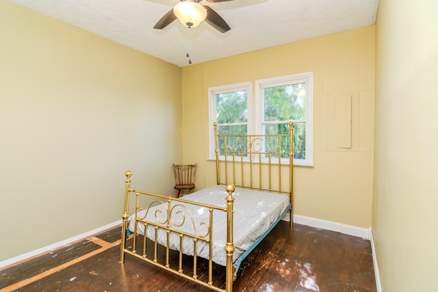bedroom with ceiling fan, dark hardwood / wood-style floors, and a textured ceiling