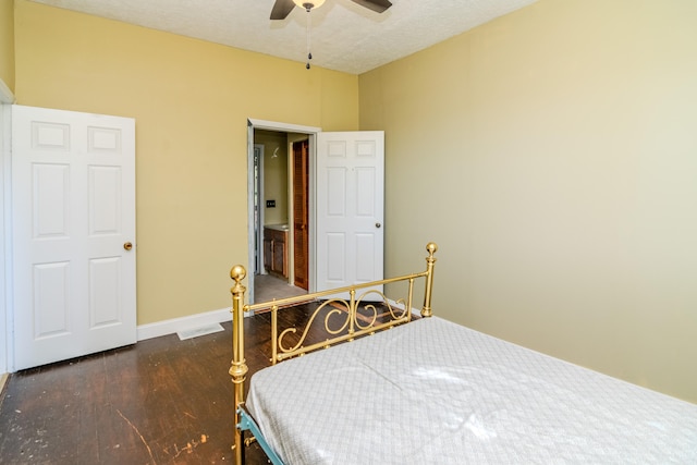 bedroom featuring dark wood-type flooring, a textured ceiling, and ceiling fan