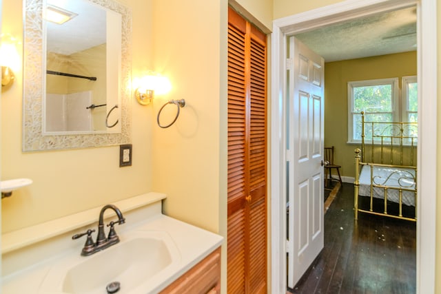 bathroom featuring hardwood / wood-style floors, vanity, and a textured ceiling