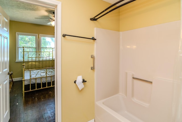 bathroom with shower / bathtub combination, hardwood / wood-style flooring, a textured ceiling, and ceiling fan