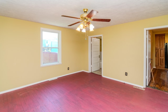 unfurnished bedroom featuring ceiling fan, black refrigerator, dark hardwood / wood-style floors, and a textured ceiling