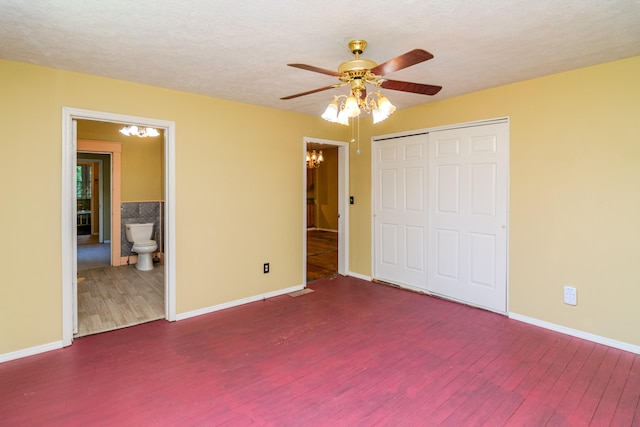 unfurnished bedroom with ceiling fan, a closet, dark hardwood / wood-style floors, connected bathroom, and a textured ceiling