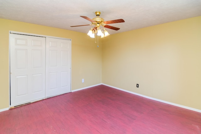 unfurnished bedroom featuring ceiling fan, a textured ceiling, a closet, and wood-type flooring