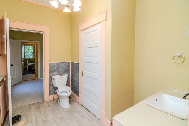 bathroom with vanity, toilet, a notable chandelier, tile walls, and hardwood / wood-style floors