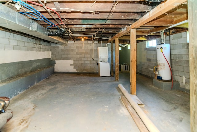 basement with water heater and stacked washer and dryer