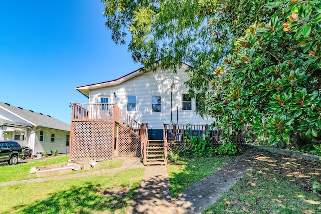 back of house featuring a deck and a lawn