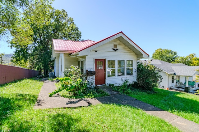view of front of home with a front yard and central AC unit
