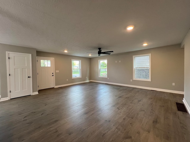 interior space with ceiling fan, dark wood-type flooring, and a textured ceiling