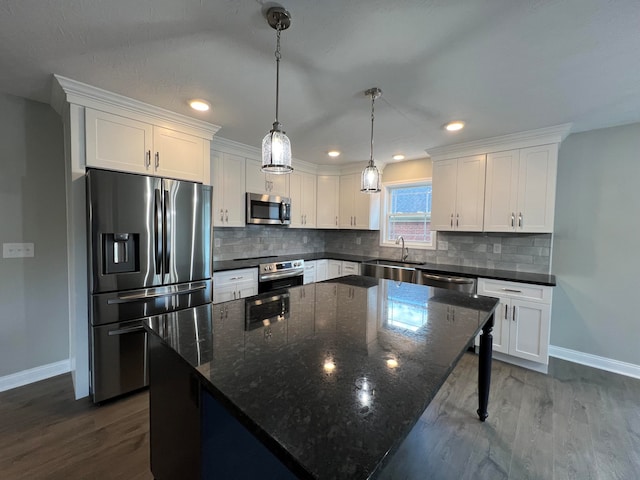 kitchen with a center island, white cabinetry, stainless steel appliances, and dark wood-type flooring