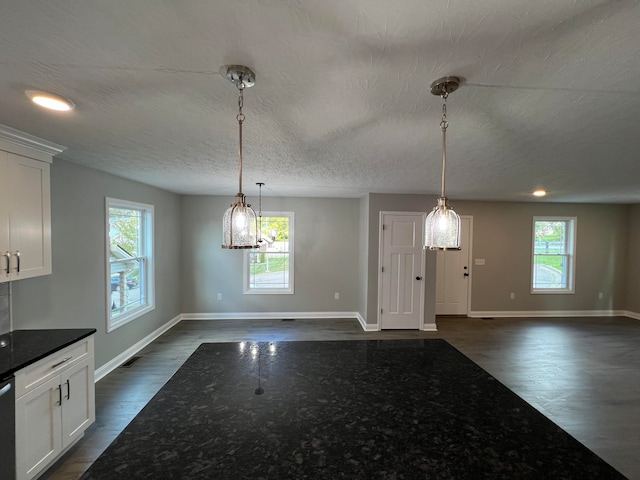 interior space featuring pendant lighting, dark hardwood / wood-style floors, white cabinetry, and a wealth of natural light