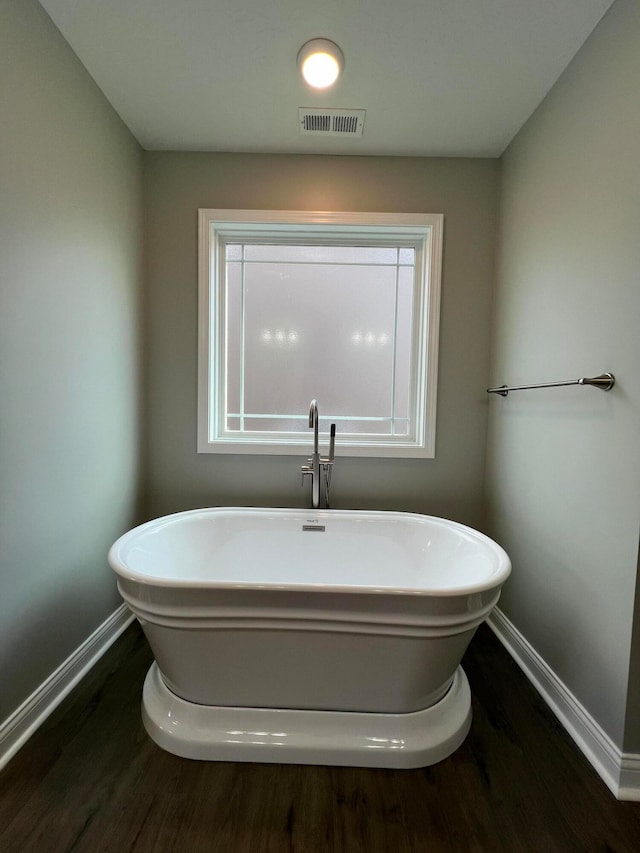 bathroom with hardwood / wood-style floors and a washtub