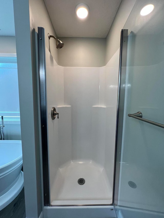 bathroom with plus walk in shower and a textured ceiling