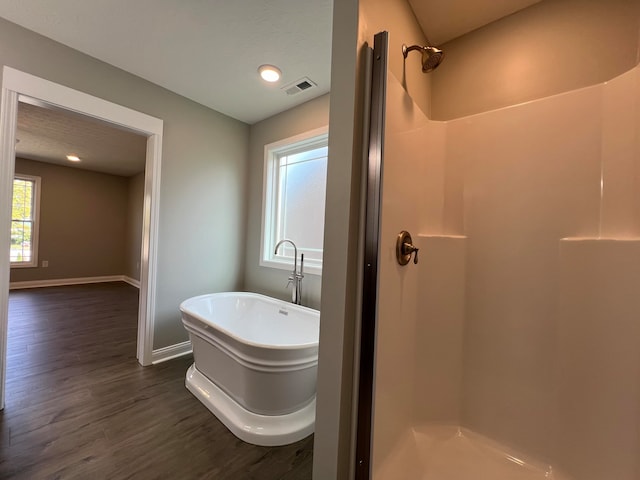 bathroom featuring hardwood / wood-style flooring and shower with separate bathtub