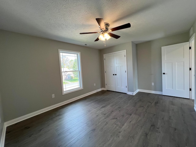 unfurnished bedroom with a closet, ceiling fan, dark hardwood / wood-style flooring, and a textured ceiling