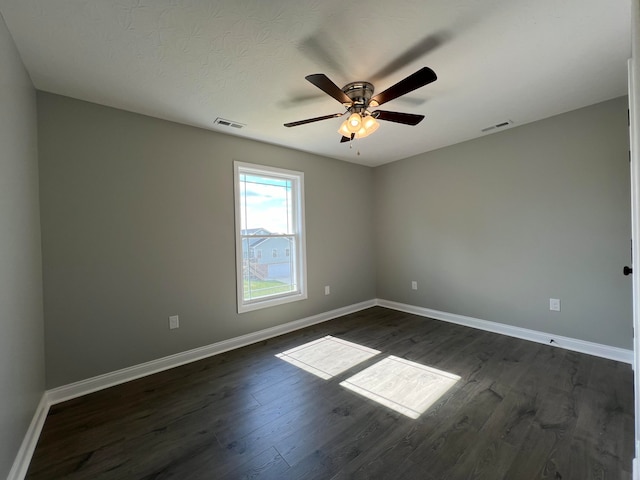 empty room with dark hardwood / wood-style flooring and ceiling fan