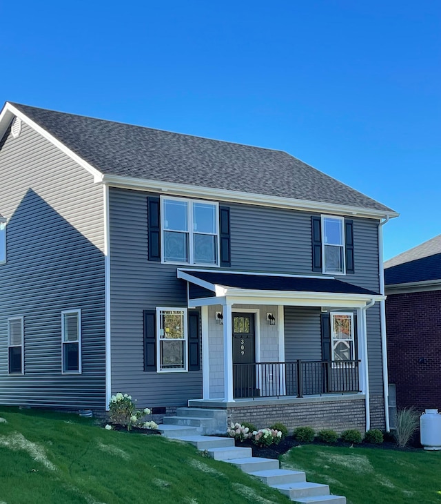 front facade with covered porch and a front lawn