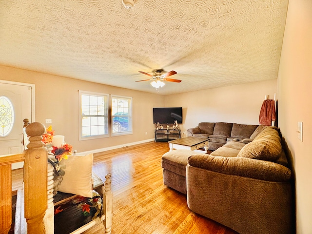 living room featuring a textured ceiling, ceiling fan, and light hardwood / wood-style flooring