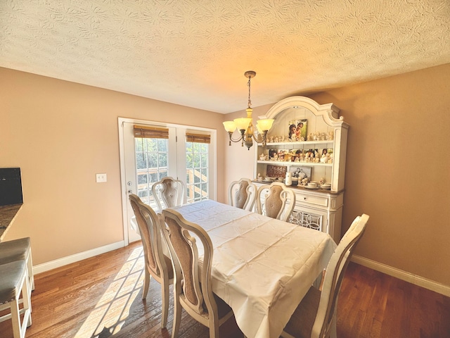 dining area with a notable chandelier, hardwood / wood-style floors, and a textured ceiling