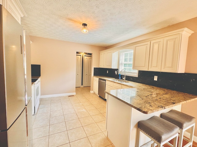 kitchen featuring light tile patterned flooring, sink, kitchen peninsula, dishwasher, and a breakfast bar