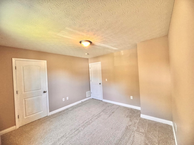 empty room with carpet and a textured ceiling