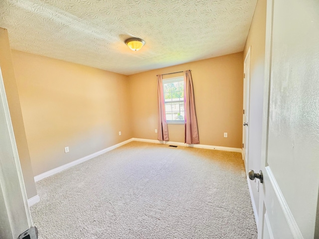 carpeted spare room with a textured ceiling