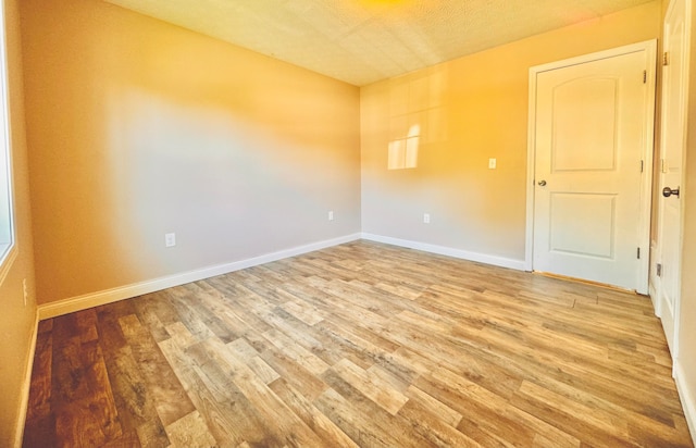 unfurnished room featuring light hardwood / wood-style floors and a textured ceiling