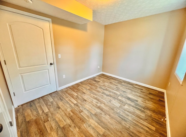 unfurnished room featuring hardwood / wood-style floors and a textured ceiling