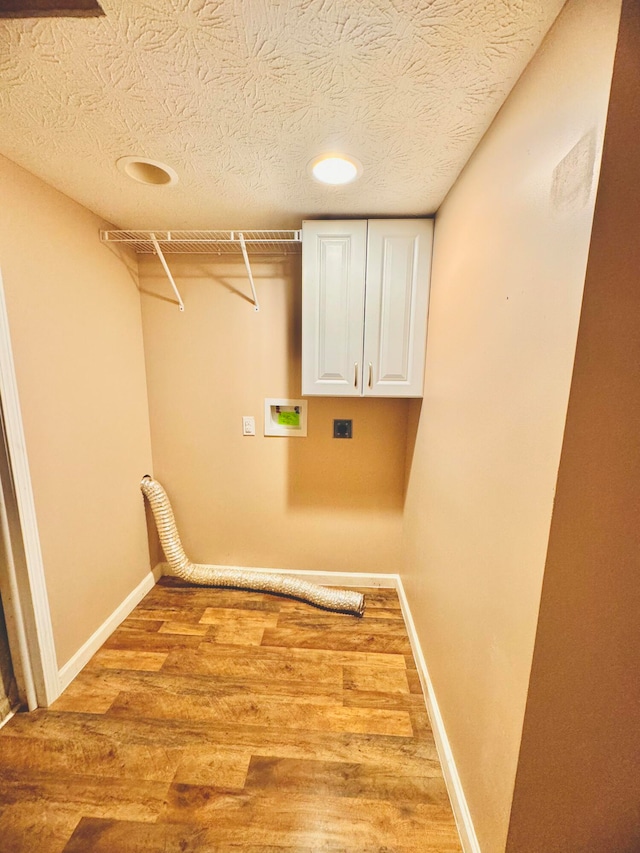 laundry area with hardwood / wood-style flooring, cabinets, washer hookup, and electric dryer hookup