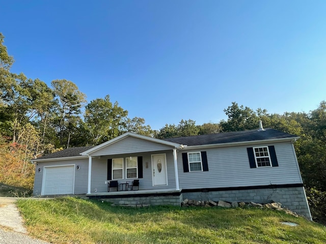 view of front of house featuring a garage, a front yard, and covered porch