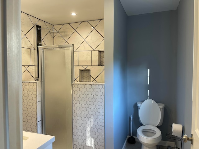 bathroom with walk in shower, vanity, and toilet