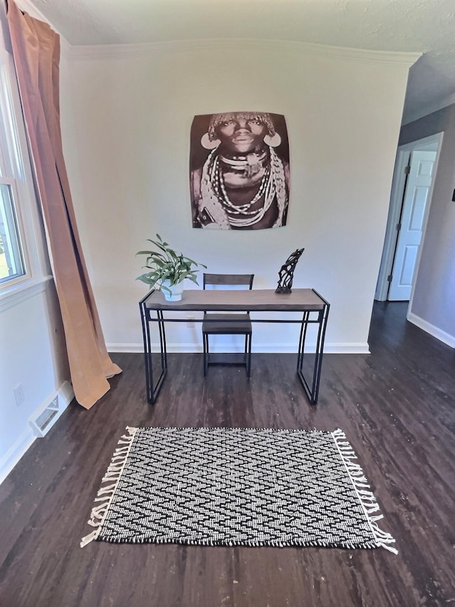 home office with ornamental molding and dark hardwood / wood-style flooring