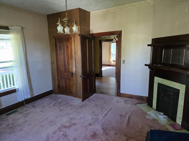 595 Bethel Ridge Rd, Sharpsburg, KY 40374 - unfurnished dining area featuring a chandelier, carpet, wallpapered walls, a fireplace with flush hearth, and baseboards