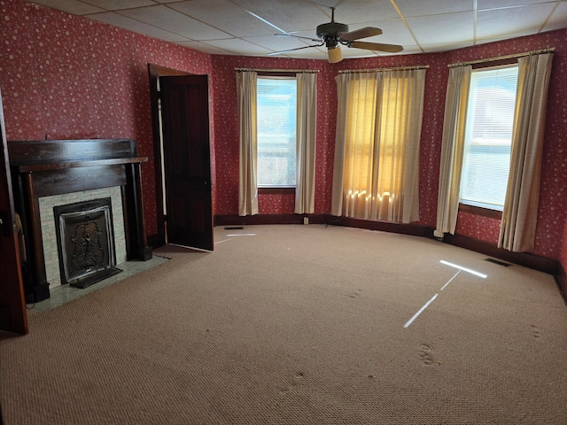 unfurnished living room with a drop ceiling, ceiling fan, and carpet floors