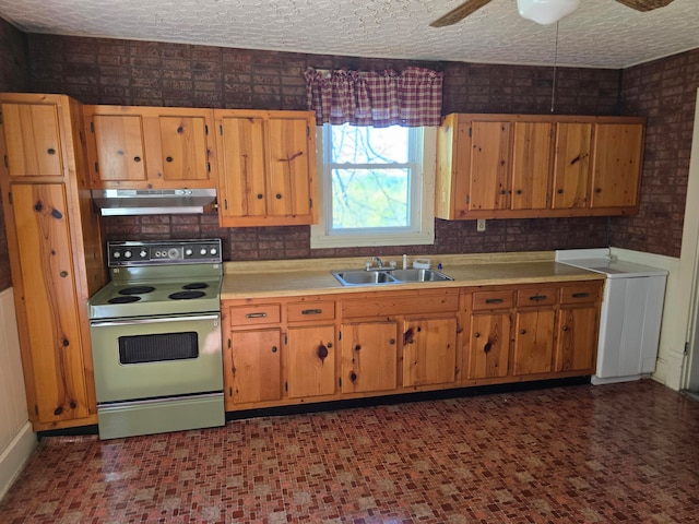 kitchen with ceiling fan, sink, a textured ceiling, electric range, and washer / dryer