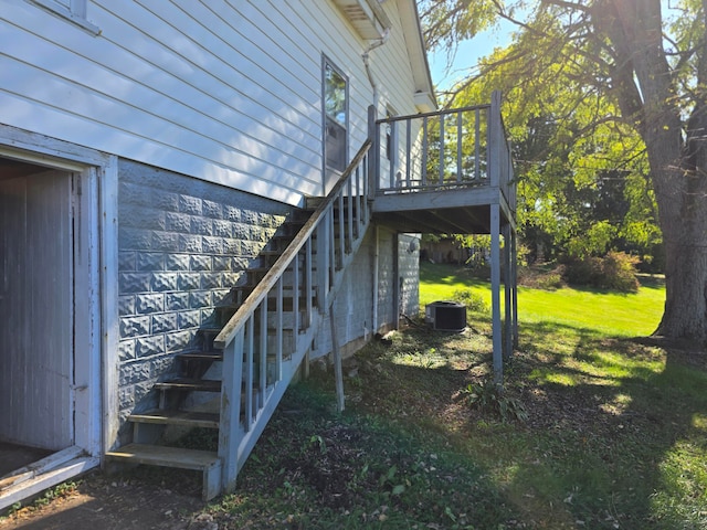 view of side of property with a yard, a wooden deck, and cooling unit