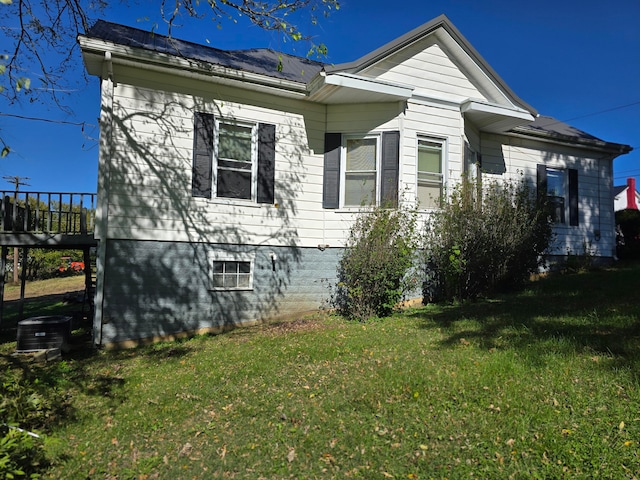 view of property exterior with cooling unit and a yard