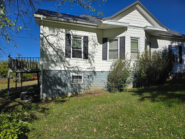 view of property exterior featuring central AC unit, a wooden deck, and a yard