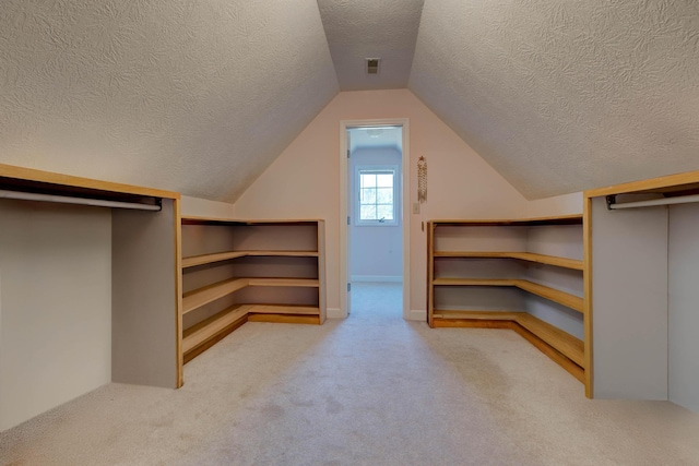 spacious closet featuring lofted ceiling and light carpet