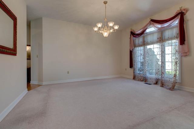 spare room with light carpet and a notable chandelier