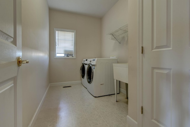 laundry room featuring light tile patterned flooring and washing machine and clothes dryer