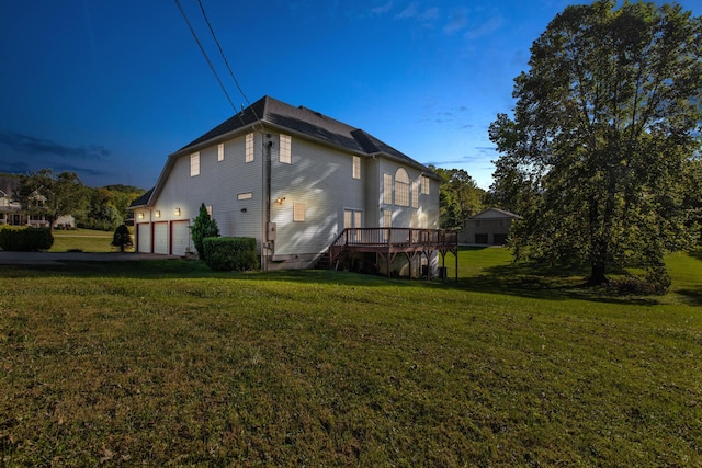 back of house with a lawn, a garage, and a deck