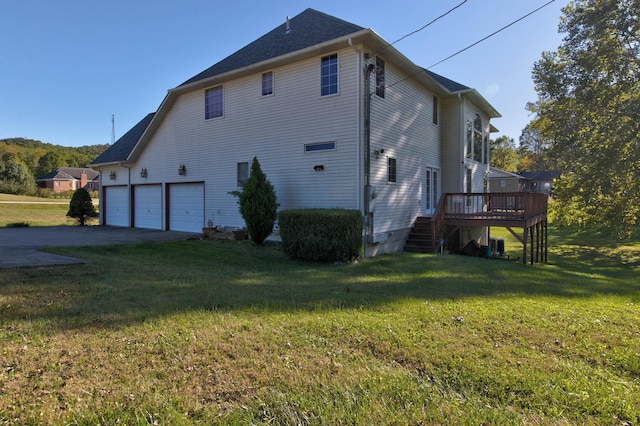 back of house featuring a deck, cooling unit, and a lawn