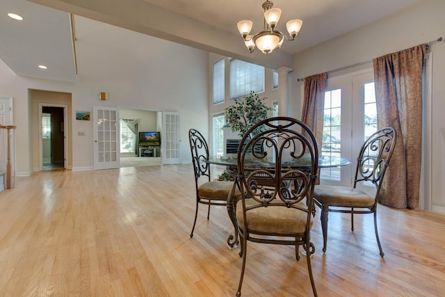 dining area featuring french doors, light hardwood / wood-style floors, and a notable chandelier