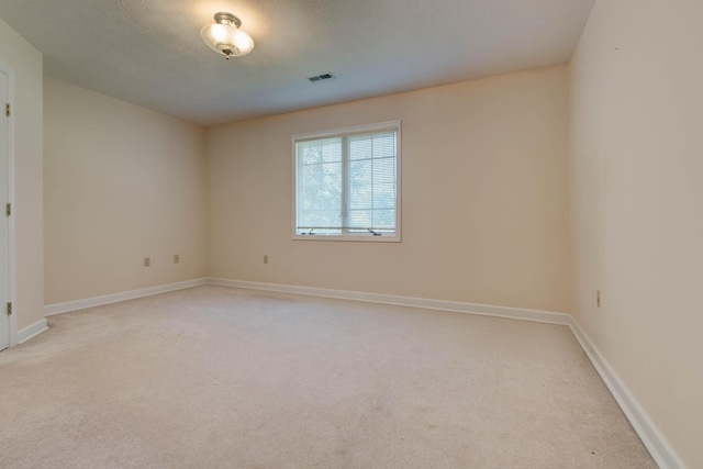 carpeted empty room featuring a textured ceiling