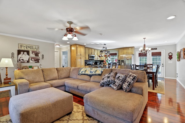 living room featuring wood-type flooring, ceiling fan with notable chandelier, and crown molding